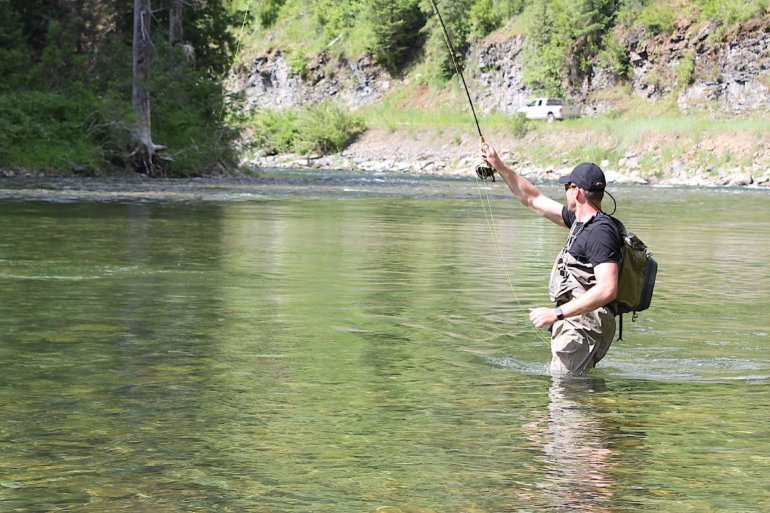 This Orvis Silver Sonic Convertible-Top Waders review photo shows a fly fisher wearing the Orvis waders in a river.