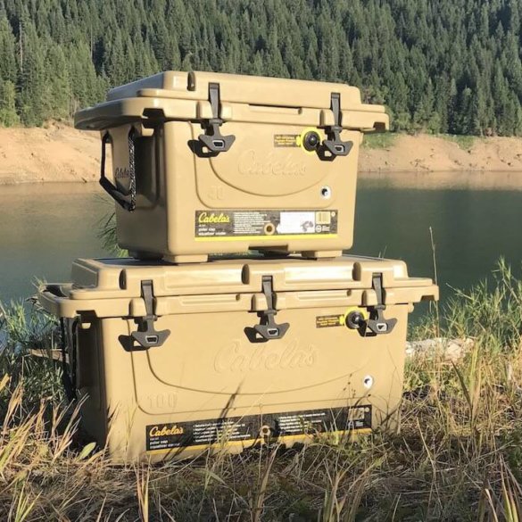 This image shows the Cabela’s Polar Cap Equalizer Cooler on the bank of a lake.