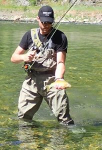 This image shows the Orvis Silver Sonic Convertible-Top Waders for fly fishing in use on a river.