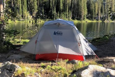 This photo shows the REI Co-op Quarter Dome 2 Tent near a mountain lake in a backpacking wilderness area.