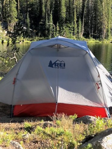 This photo shows the REI Co-op Quarter Dome 2 Tent near a mountain lake in a backpacking wilderness area.