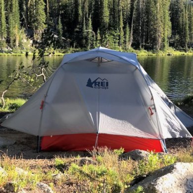 This photo shows the REI Co-op Quarter Dome 2 Tent near a mountain lake in a backpacking wilderness area.