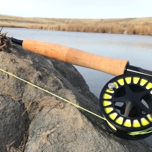 This photo shows the Cabela's Rogue Fly Rod on a rock near a creek.