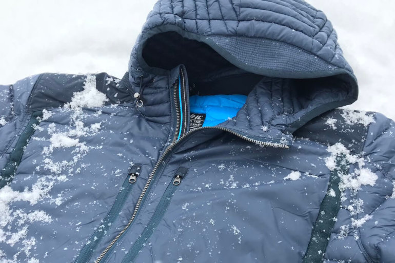 This photo shows a closeup of the KUHL SPYFIRE HOODY down jacket with a small bit of snow.