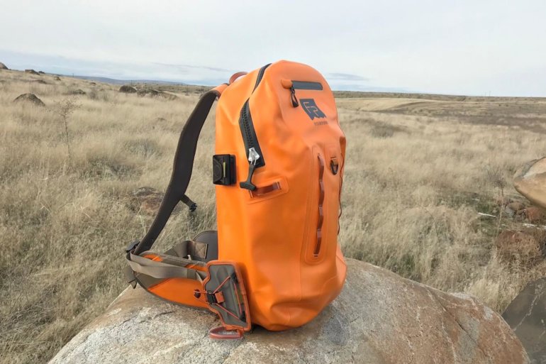 This photo shows the Fishpond Thunderhead Submersible Backpack outside on a rock.