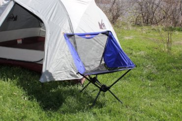 This camp chair photo shows the REI Co-op Flexlite Macro Chair in front of a tent.