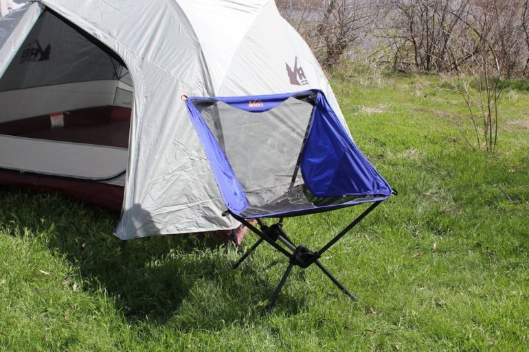 This camp chair photo shows the REI Co-op Flexlite Macro Chair in front of a tent.