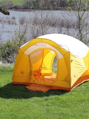 This photo shows the Big Agnes Big House 4 Deluxe camping tent set up near a river.