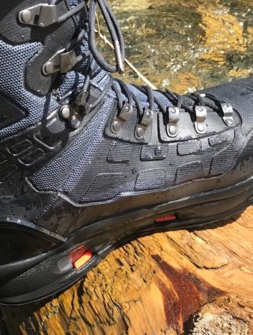 This Korkers WRAPTR review photo shows the Korkers WRAPTR Wading Boots on a wet log.
