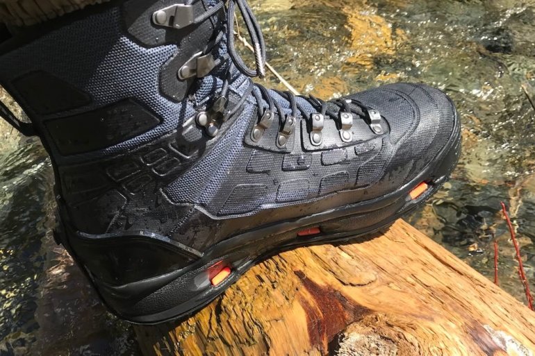 This Korkers WRAPTR review photo shows the Korkers WRAPTR Wading Boots on a wet log.