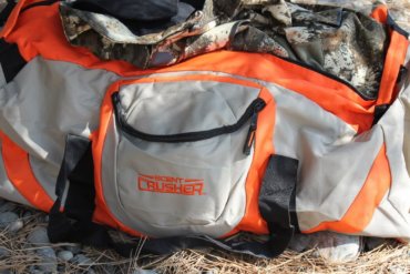 This Scent Crusher Ozone Gear Bag review photo shows the Ozone Gear Bag with some camo hunting clothes.