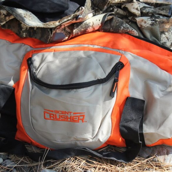 This Scent Crusher Ozone Gear Bag review photo shows the Ozone Gear Bag with some camo hunting clothes.