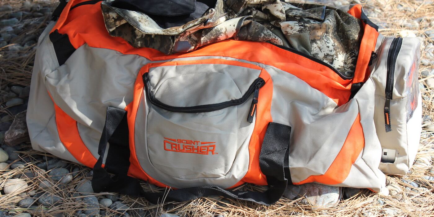 This Scent Crusher Ozone Gear Bag review photo shows the Ozone Gear Bag with some camo hunting clothes.