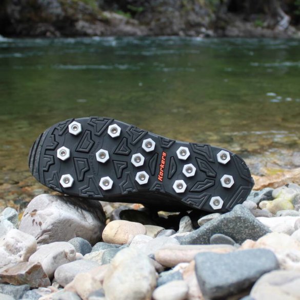 This photo shows the Korkers Triple Threat Aluminum Hex Disc Soles next to a river.