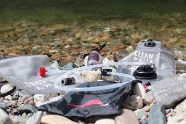 This photo shows the MSR Trail Base Water Filter Kit near a river.