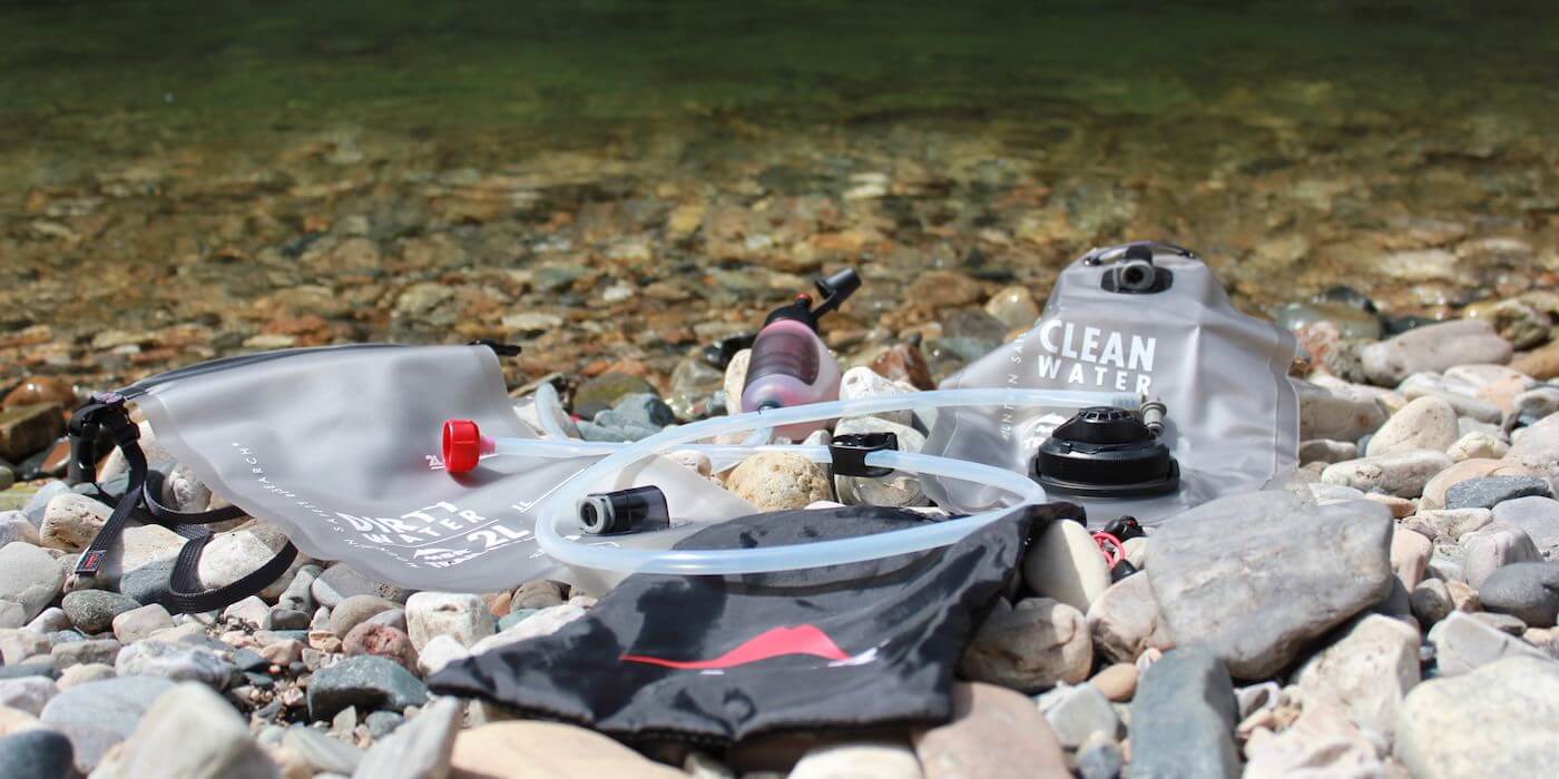 This photo shows the MSR Trail Base Water Filter Kit near a river.
