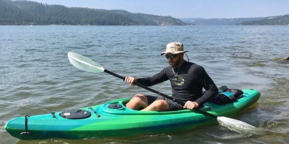 This photo shows the author wearing the Shelta Seahawk hat in a kayak on a lake from the front view.