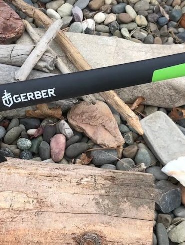 This photo shows the Gerber 23.5" Axe sticking into a piece of firewood.
