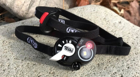This photo shows the Petzl e+LITE Emergency Headlamp with the red led light on.