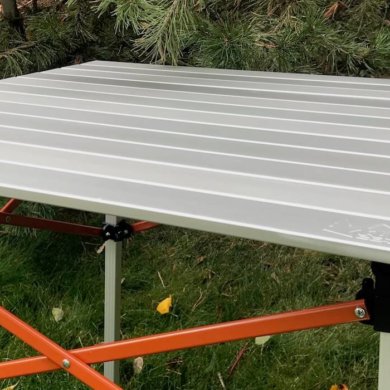 This photo shows the REI Co-op Camp Roll Table outside at a camping spot.