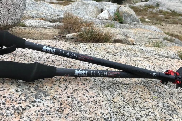 This photo shows the The REI Co-op Flash Carbon Trekking Poles on a rock outside.