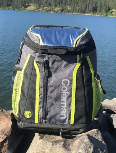 This image shows the Coleman Maverick Ultra Backpack Cooler near a lake.
