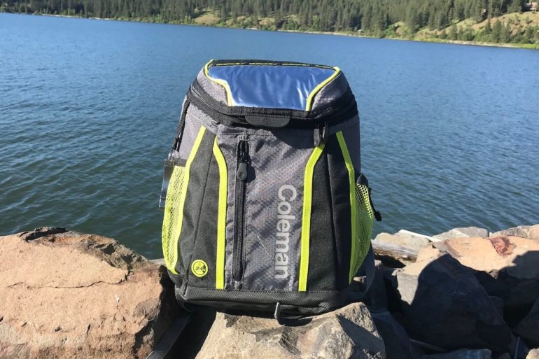 This image shows the Coleman Maverick Ultra Backpack Cooler near a lake.
