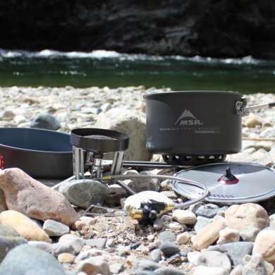 This photo shows the MSR WindBurner Stove System Combo outside near a mountain river.