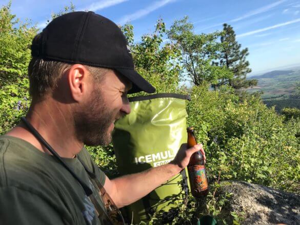 This backpack cooler guide photo shows the author with a backpack cooler and a cold drink.