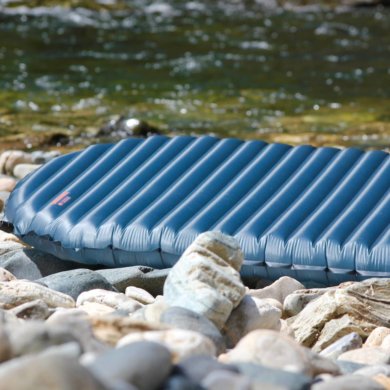 This review photo shows the Therm-a-Rest NeoAir UberLite air mattress outside on some rocks.