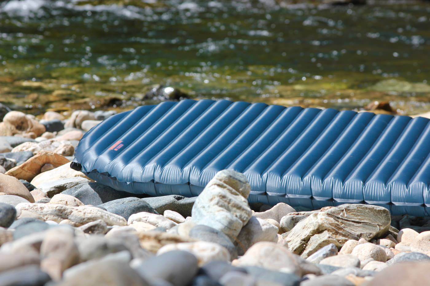 This review photo shows the Therm-a-Rest NeoAir UberLite air mattress outside on some rocks.