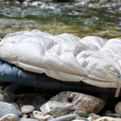 This review photo shows the Therm-a-Rest Vesper Quilt outside on top of a Therm-a-Rest NeoAir UberLite air mattress for backpacking.