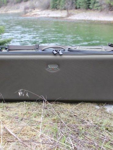 The review photo shows the Simms Bounty Hunter Vault Duffel outside near a river.