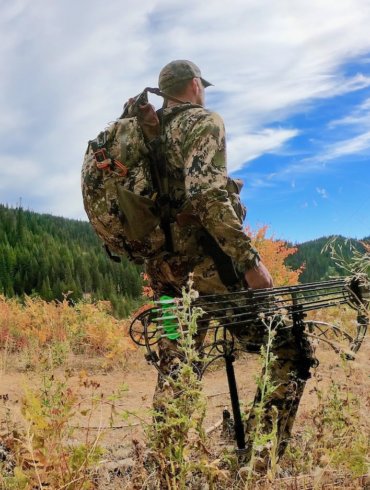 This photo shows a hunter wearing the Mystery Ranch Mule backpack outside.