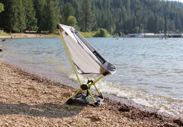 This review photo shows the Helinox Chair Zero on a beach near a lake.