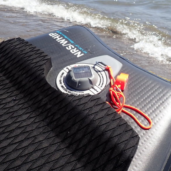 This review photo shows the TRīB airCap Pressure Gauge on an inflatable SUP paddle board on a beach.