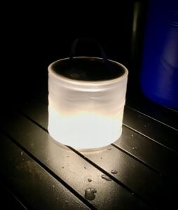 This photo shows the MPOWERD Luci Pro Series solar light at night on a camping table.