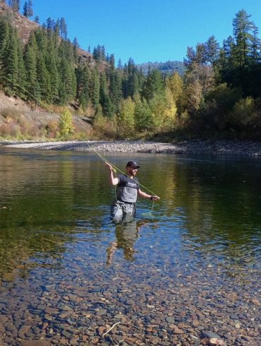 This photo shows a fly fisherman wading in a river while wearing the Orvis PRO Wader.
