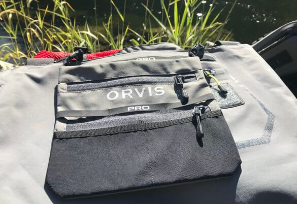 This photo shows the Orvis Pro Wader front flip pocket near a river.