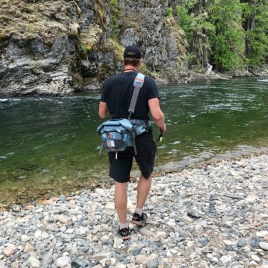 This fishing gift guide photo shows a fisherman fishing near a river.