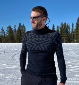 This photo shows a man wearing the Odlo Natural + Kinship Warm Base Layer Top with Face Mask.