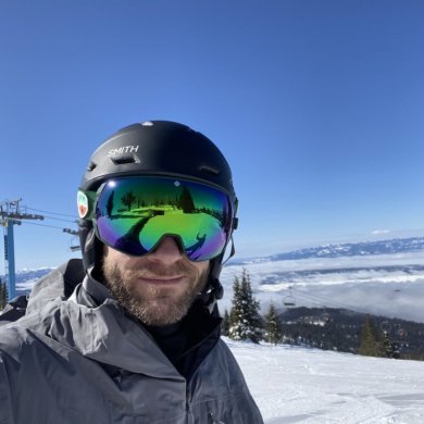 This photo shows a skier wearing the SPY Legacy Snow Goggle while outside on the ski slopes.