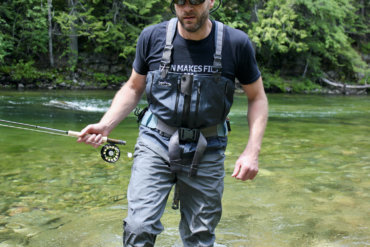 This best fishing waders image shows the author testing fishing waders on a river while fishing.