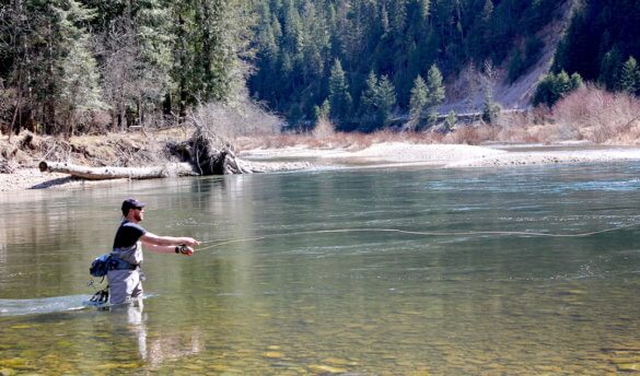 This photo shows the author fly fishing with the Orvis Recon Fly Rod on a river for trout.