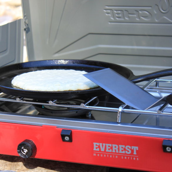 This review photo shows the Camp Chef Everest Two-Burner Camping Stove with a cooking pancake.