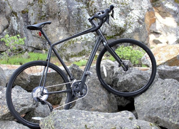 This review photo shows the Cannondale Topstone AL 105 gravel bike standing in rocks next to a gravel road.