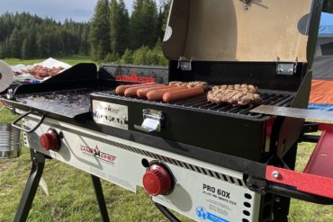 This review photo shows the Camp Chef PRO 60X camping stove being used to cook dinner outside while camping.