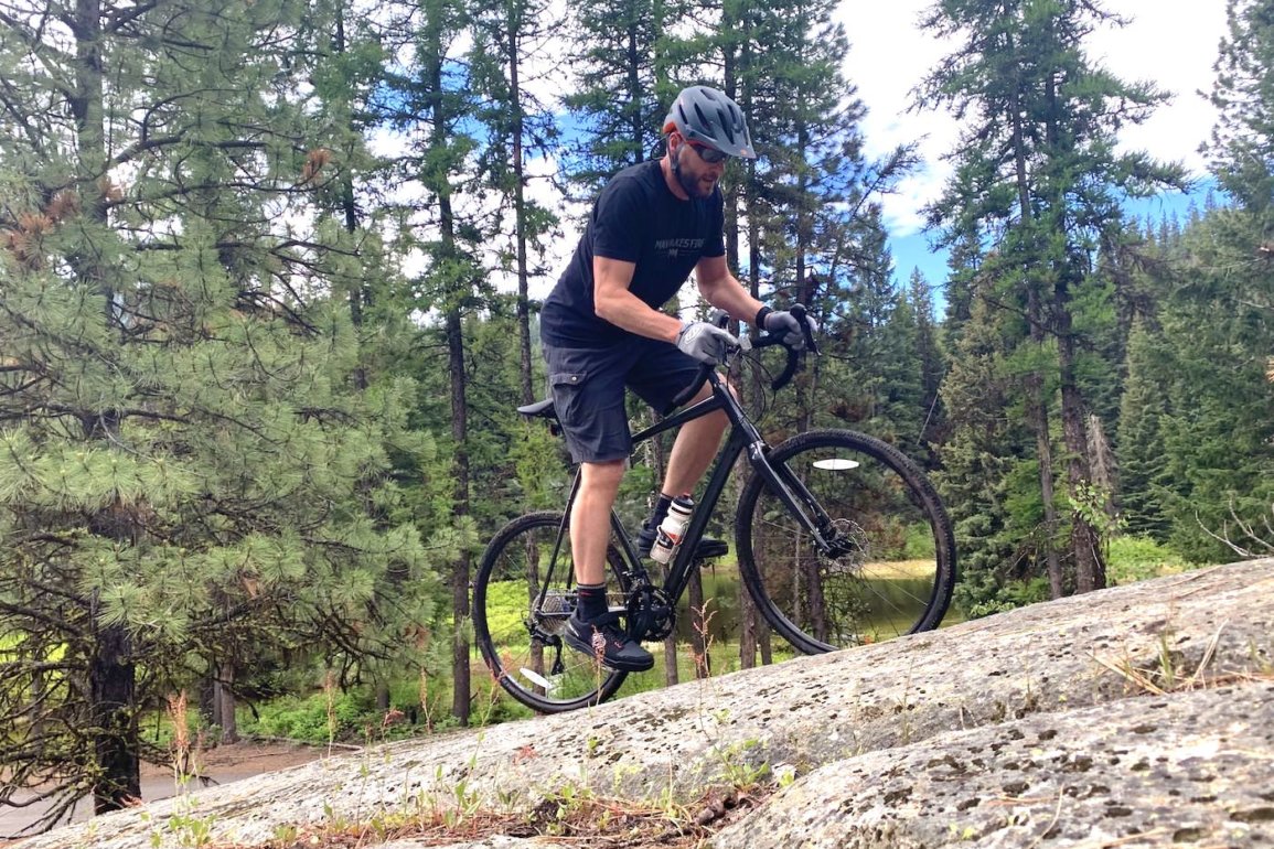 This review photo shows the author testing the Cannondale Topstone AL 105 gravel bike by riding off-road outside.