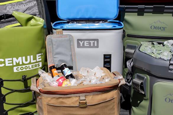 This soft cooler review and testing photo shows YETI, ICEMULE, OtterBox, Coleman, and Fishpond soft-sided coolers next to each other with ice.