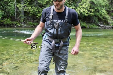 Author Chris Maxcer wearing the Patagonia Expedition Zip-Front Waders while fly fishing on a river in Idaho.